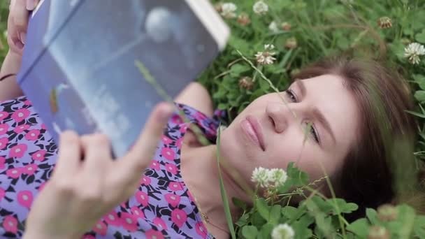 Mujer joven leyendo libro en el parque — Vídeos de Stock