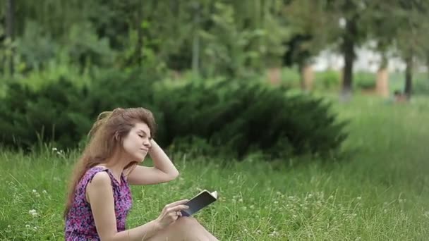 Ziemlich entspannte erwachsene Frau liest ein Buch im Park — Stockvideo