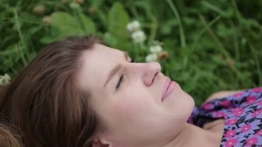 Çim yakın çekim yalan güzellik genç romantik kız. Yeşil gözlü esmer modeli kız.
