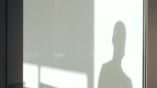 Мужчина вешает табличку на стеклянную дверь — стоковое видео
