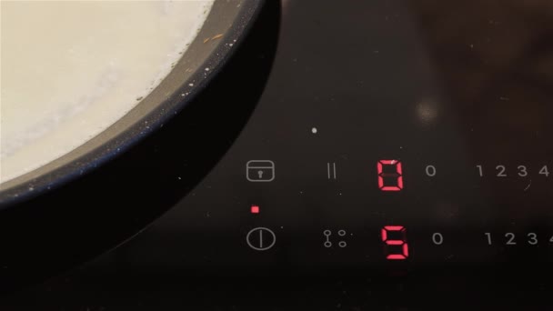 Pannenkoeken bakken op een koekenpan op de inductiekookplaat. — Stockvideo