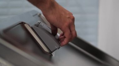 Adamın biri çamaşır makinesine tablet koyuyor. 4K görüntü