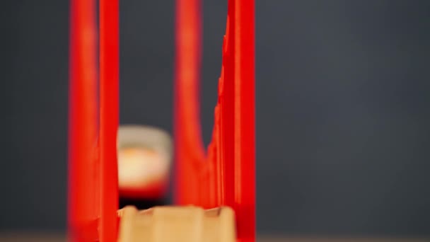 Tren eléctrico de juguete moviéndose en un puente rojo — Vídeo de stock