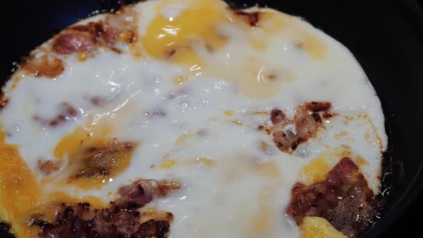 Смажені яйця на сковороді з беконом — стокове відео