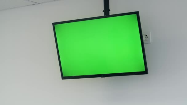 TV a schermo piatto con schermo verde. TV a chiave cromatica su parete bianca — Video Stock