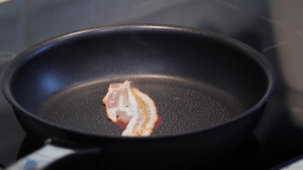 Pedaços de bacon cozinhar em uma frigideira — Vídeo de Stock