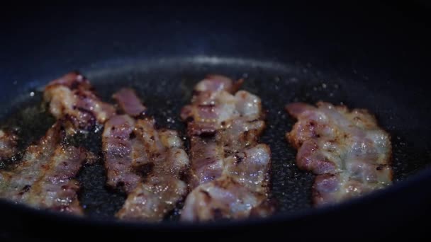 Bacon och ägg tillagas i stekpanna. Bitar av bacon och ägg. — Stockvideo