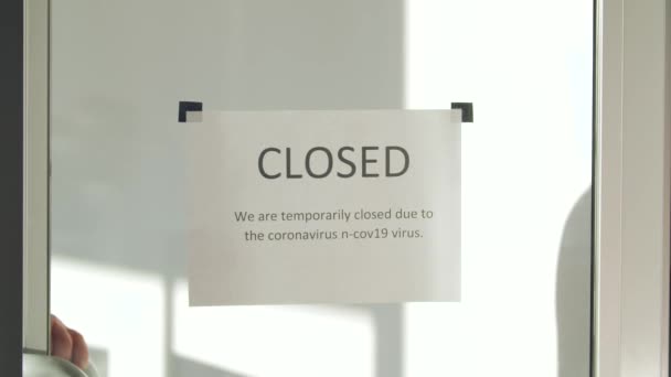 Umieszczenie zamkniętego znaku na szklanych metalowych drzwiach — Wideo stockowe