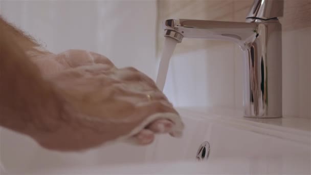 Λευκός άνδρας καθαρίζει τα χέρια σε καθαρό νερό από βρύση ή βρύση κοντά σε αργή κίνηση. — Αρχείο Βίντεο