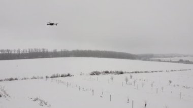 Siyah bir dron kameranın önünde uçuyor..