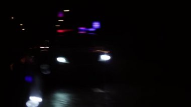 Arabanın sol tarafındaki ayna polis arabasının hareket ettiğini gösteriyor. Polis arabasının hafif bulanıklığı.
