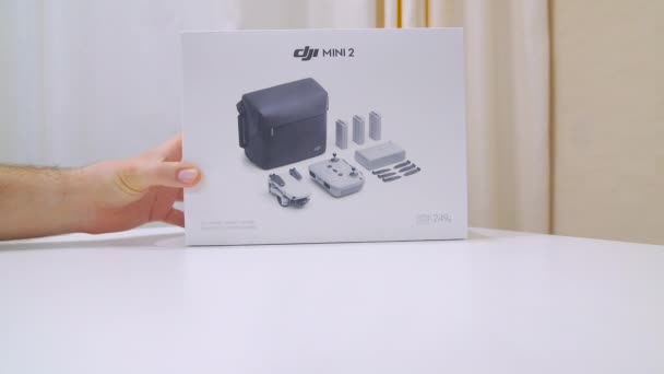 Close-up of a man hand rotation packaging box with new DJI mini2. 01.06.2021 - Russia, Orel — Stockvideo