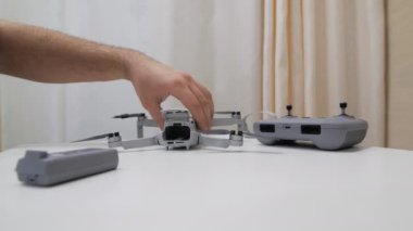Erkeklerin elleri DJI mini 2 'ye pil takıyor.
