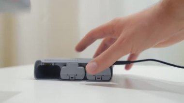 Adamların elleri şarj merkezine pil yerleştiriyor..