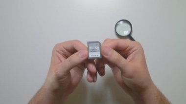 SDHC dijital hafıza depolama kartı Sony 'nin elinde. Büyüteçle yakınlaştır. Üst görünüm.