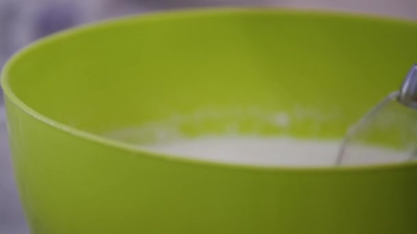 Wanita menambahkan tepung ke mangkuk dan membuat adonan dengan pencampur tangan. Extremal close-up — Stok Video