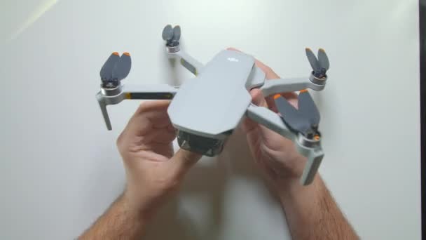 Dji mini 2 kuadkopterinin pervanelerini katlayan bir adam elleri. Üst Manzara. Yeni küçük dron. 02.09.2021 - Rusya, Orel. — Stok video