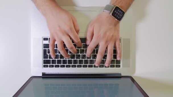 Ung frilansare eller affärsman skriva på laptop på vitt skrivbord. — Stockvideo