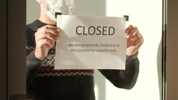 Il proprietario dell'istituzione appende un cartello chiuso alla finestra. Impatto del coronavirus in un business. — Video Stock