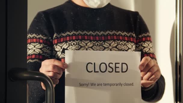 Κοντινό πλάνο άνθρωπος κρέμεται μια πινακίδα Συγγνώμη είμαστε προσωρινά κλειστά — Αρχείο Βίντεο