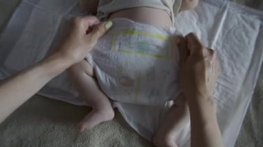 Yakın plan anne yeni doğan bebeklerin bezini bağlıyor. Annelik kavramı.