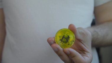 Kafkasyalı adamı elinde tutan bitcoin para. 4K görüntü.