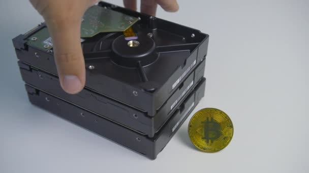 Man hand ta bort hårddisk enhet från stack. Bitcoin står på det vita bordet. Cryptocurrency gruvdrift — Stockvideo