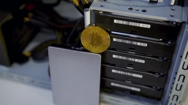 Концепция добычи криптовалют. Добыча монет Chia с помощью жестких дисков. Жетон Gold bitcoin перед жестким диском. — стоковое видео