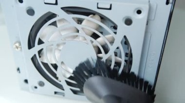 Bilgisayar hizmetini kabul et. Elektrikli süpürgeyle beyaz bilgisayar vantilatörü temizleniyor.