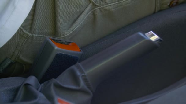 El hombre se abrocha el cinturón de seguridad en el coche y comienza a conducir. Primer plano del cinturón de seguridad de tres puntos. — Vídeo de stock