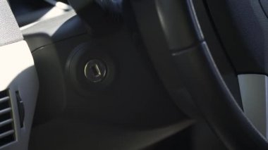 Erkek eli, anahtarı kontak kilidine yerleştirir. Sağdaki araba.