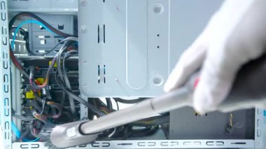 İşçi, tozdan ekipman birimleri ya da elektrik süpürgesiyle kir ile bilgisayar temizler.