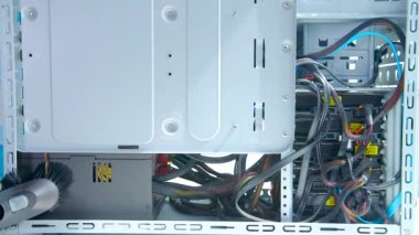  Beyaz eldivenli bir adam elektrikli süpürge ile bilgisayarı temizliyor.