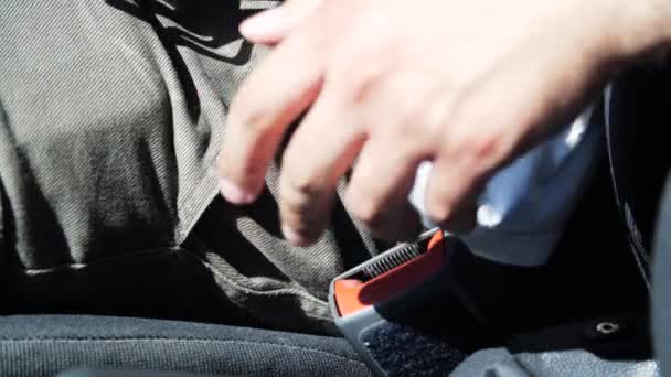 Homme main détacher la ceinture de sécurité de la voiture tout en étant assis à l'intérieur du véhicule. — Video