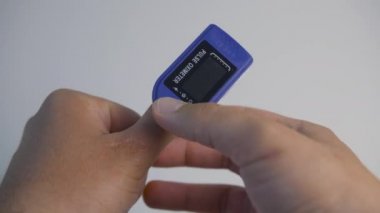 Yetişkin bir insan oksijen doygunluğunu ölçmek için nabız oksimetresini kullanır. 4k görüntü.