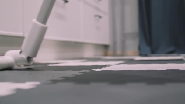 現代のハンドスティック掃除機で床を掃除する男. — ストック動画