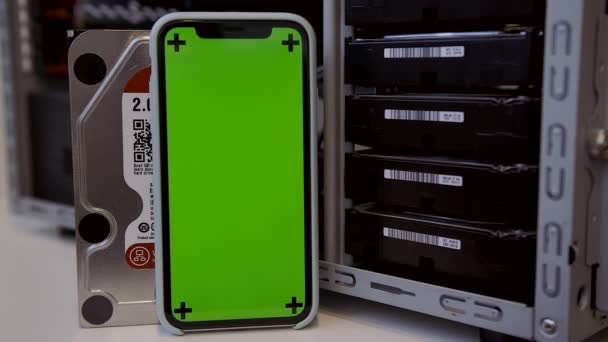 在服务器或数据中心上使用集群硬盘阵列挖掘比特币。带有绿色色键的智能手机。新的HDD — 图库视频影像