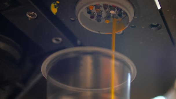 Dosering av gult färgämne i en transparent behållare. Slow motion-film. — Stockvideo