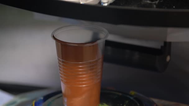 Dispensador automático profesional de colorantes. Dosificación del proceso de coloración marrón en un recipiente transparente. — Vídeo de stock