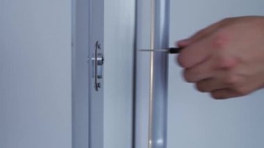 4k 'lık yakın çekim adamı kapının kilidine bir anahtar yerleştirir ve kapatır..