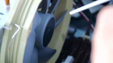 Bilgisayar teknisyeni sıkıştırılmış havayı işlemci vantilatörüne üflüyor. Bir işlemci vantilatörü temizleniyor