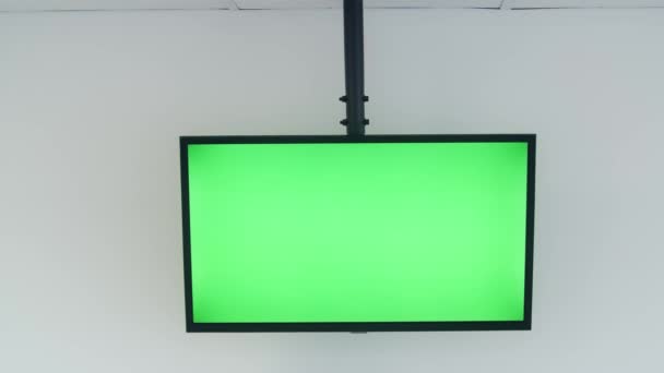 Big green screen TV in a white well lit conference room with nobody in it — Stock Video