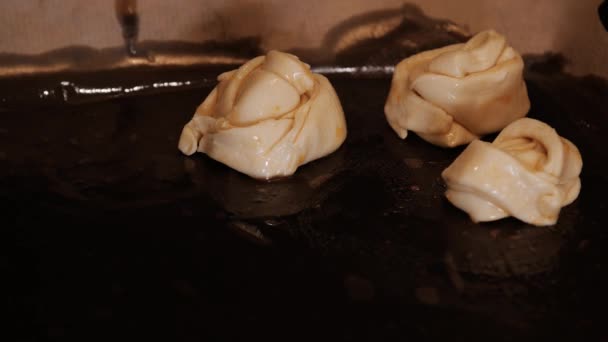 Rauwe gedraaide zoete broodjes op de bakplaat — Stockvideo