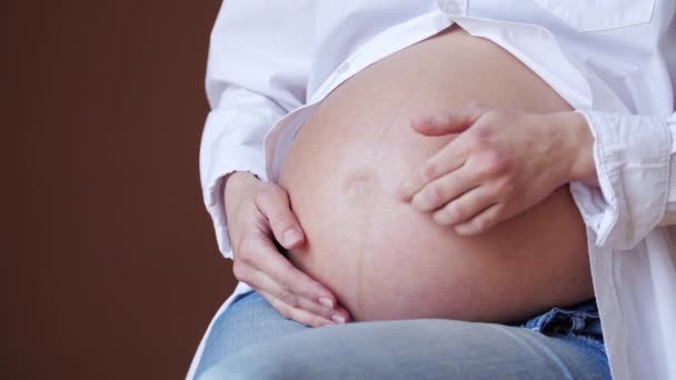 小孩在一个年轻母亲的肚子里推挤. — 图库视频影像