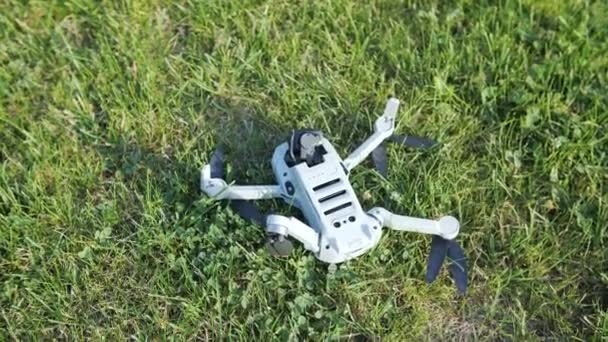 Un quadrocopter roto en la hierba verde. Choque de drones — Vídeo de stock