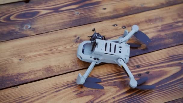 Cámara rota de un dron sobre una superficie de madera. Choque de drones — Vídeo de stock