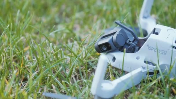 Close-up view drone after crash on grass in summer park — Stock Video