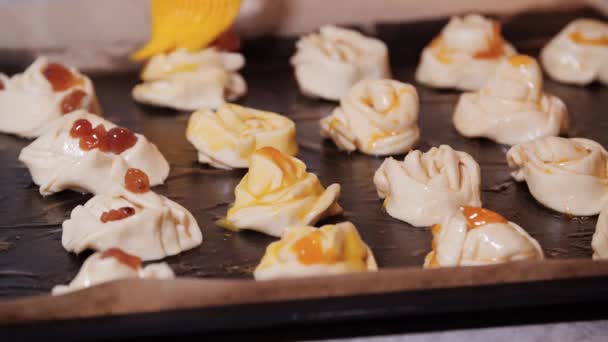 Die Brötchen auf dem Backblech werden mit Eigelb eingefettet — Stockvideo