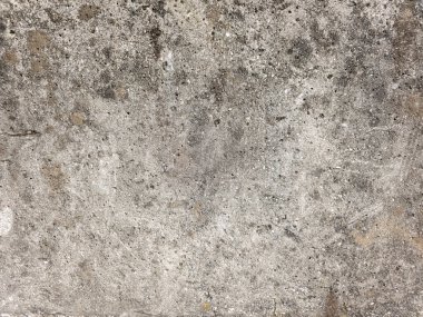 Close up of an old weathered gray concrete wall. The rough, grungy surface shows signs of aging and wear, creating an abstract textured background perfect for design projects, wallpaper, or overlays.