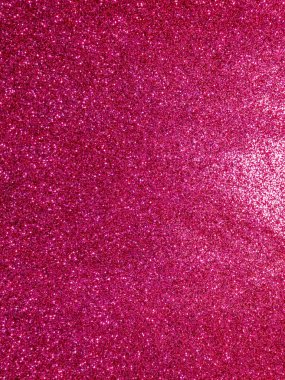 Canlı pembe bir parıltı yüzeyinin makro görüntüsü. Parlak dokusu, bayram tasarımları, parti davetiyeleri, duvar kağıtları ve soyut kavramlar için mükemmel bir şenlik ve büyüleyici bir zemin oluşturuyor..